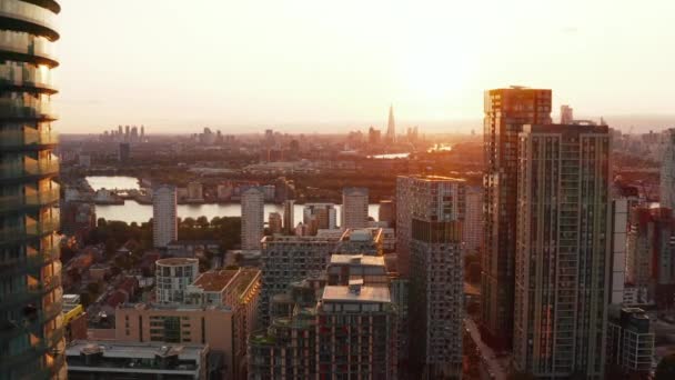 Revelación de edificios en el barrio de Canary Wharf. Vista aérea panorámica del paisaje urbano contra la puesta de sol. Londres, Reino Unido — Vídeos de Stock