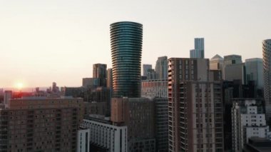 Modern işletme Canary Wharf kasabasındaki gökdelenlerin yükselen görüntüleri. Gün batımına karşı Silindirik Arena Kulesi yerleşim yeri. Londra, İngiltere