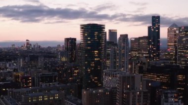 Modern iş kentsel bölgesinin mavi saatte yüksek gökdelenleri olan panorama eğrisi. Şehirler pembe alacakaranlık gökyüzüne karşı. Londra, İngiltere