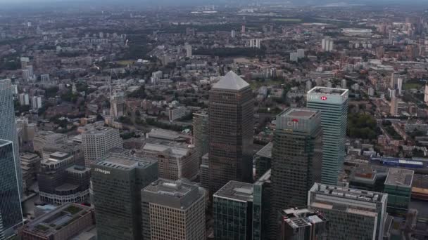 Vista aérea do edifício moderno alto em torno da Praça do Canadá no distrito de negócios Canary Wharf. Canadá, HSBC, Citi e outros arranha-céus de escritório após o pôr do sol. Londres, Reino Unido — Vídeo de Stock