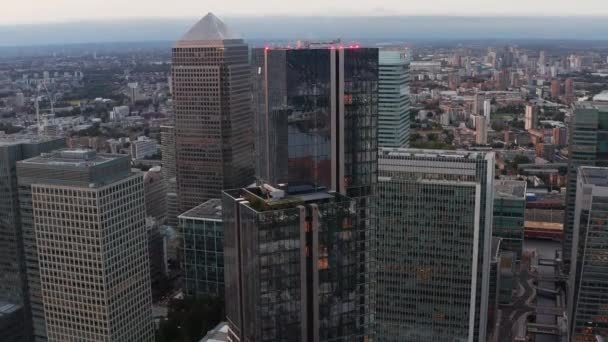 Ascending footage of top part of South Quay Plaza building. Glossy glass covered skyscraper on Isle of Dogs. Group of tall towers in Canary Wharf business hub. London, UK — Stock Video