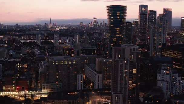 En avant survolez la ville du soir. gratte-ciel dans le quartier urbain moderne après le coucher du soleil. Paysage urbain contre ciel rose. Londres, Royaume-Uni — Video