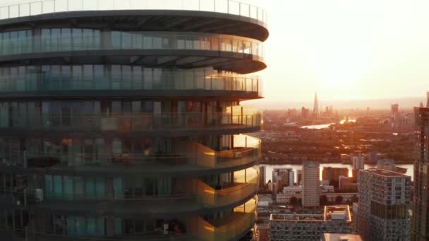 Trek beelden van futuristische cilindrische flatgebouw Arena Tower en skyline tegen zonsondergang hemel op de achtergrond. Londen, Verenigd Koninkrijk — Stockvideo