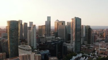 İş merkezi Canary Wharf 'taki yüksek ofis binalarının yükselişi. Güneş batarken yankılanıyor. Altın saatte gökdelenler. Londra, İngiltere