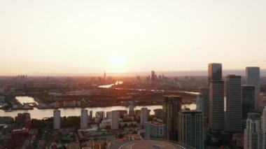 Gün batımında şehrin hava panoramik görüntüleri. Canary Wharf 'ın finansal merkezindeki gökdelenlerin tersten görünümü. Londra, İngiltere