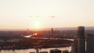 Şehrin üzerinde romantik günbatımı. Şehir boyunca kıvrılan Thames nehrinin geniş açılı görüntüsü. Akşam manzarası. Londra, İngiltere