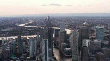 Canary Wharf iş merkezinin havadan panoramik görüntüsü. Yüksek ofis ve apartmanlar eski limanların su kanallarının üstünde yükseliyor. Londra, İngiltere
