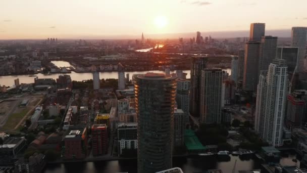 Omloop rond Arena Tower gebouw. Panoramisch uitzicht op het stadsgezicht met wolkenkrabbers in Canary Wharf financiële hub bij zonsondergang. Londen, Verenigd Koninkrijk — Stockvideo