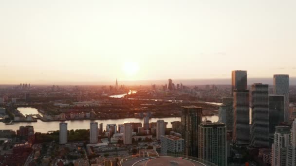 Imagens panorâmicas aéreas da cidade ao pôr-do-sol. Revelação para trás de arranha-céus no centro financeiro Canary Wharf. Londres, Reino Unido — Vídeo de Stock