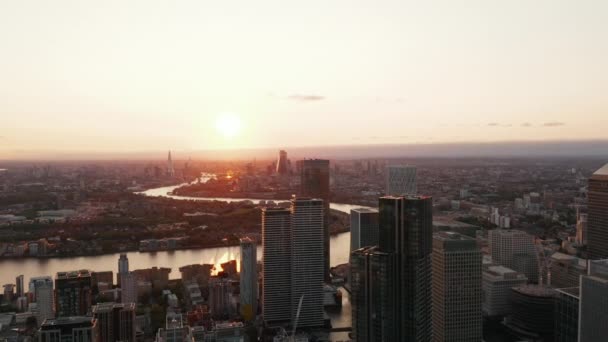 Le quartier des affaires de Canary Wharf dévoile à l'envers de grands bâtiments modernes. Images panoramiques aériennes contre le coucher du soleil. Londres, Royaume-Uni — Video