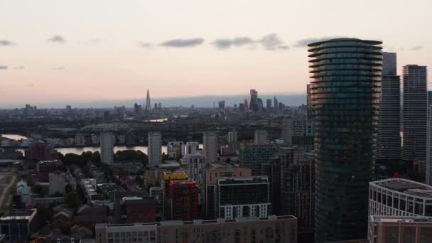 En avant voler autour Arena Tower gratte-ciel de l'île des chiens. vue panoramique sur le paysage urbain contre un ciel lumineux après le coucher du soleil. Londres, Royaume-Uni — Video