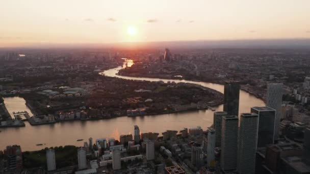 Повітряний панорамний вид на велике місто. Романтичний захід над столицею Британії. Поверхня води річки Віндінг Темзи відображає барвисте небо. Лондон, Велика Британія — стокове відео