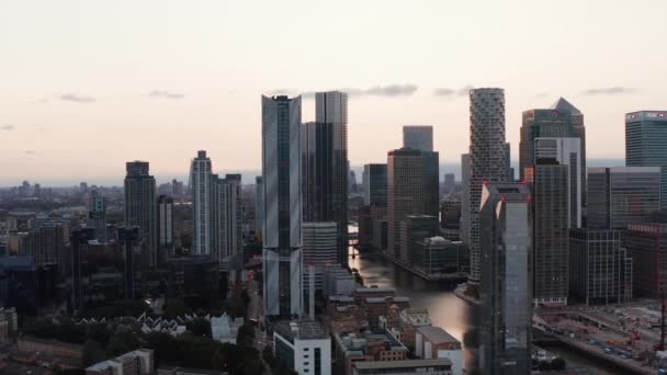 Scorrevole e pan filmato di moderni edifici alti lungo il canale d'acqua del bacino sud nel tempo del tramonto. Futuristico hub finanziario di Canary Wharf. Londra, Regno Unito — Video Stock