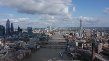 Thames Nehri 'nin üzerinden geriye doğru uçarak şehir bölgesindeki modern gökdelenleri, Millennium yaya köprüsünü ve Tate Modern Sanat Galerisini gözler önüne serdi. Şehir merkezinin havadan görünüşü. Londra, İngiltere