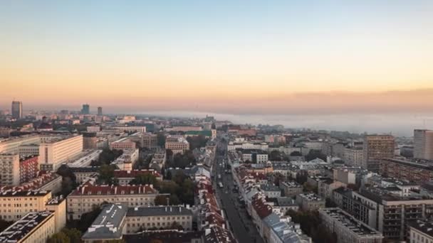 Der Morgen verfliegt rückwärts über dem Stadtviertel. Hyperlapse des Stadtbildes bei Sonnenaufgang, Nebelschwaden im Hintergrund. Warschau, Polen — Stockvideo