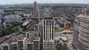 White City 'deki modern apartmanların tersten görünümü. Şehir çevresi ve arka planda geniş bir çayırı olan park. Londra, İngiltere