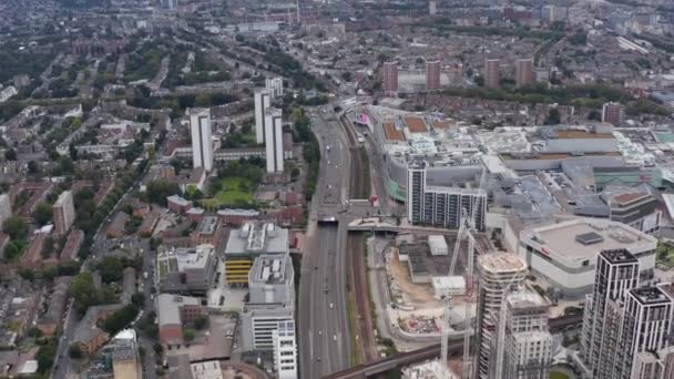 Blick aus der Vogelperspektive auf einen modernen Komplex mit hohen Wohngebäuden und einem riesigen Einkaufszentrum. Tilt up aufschlussreichen Stadtbild. London, Großbritannien — Stockvideo