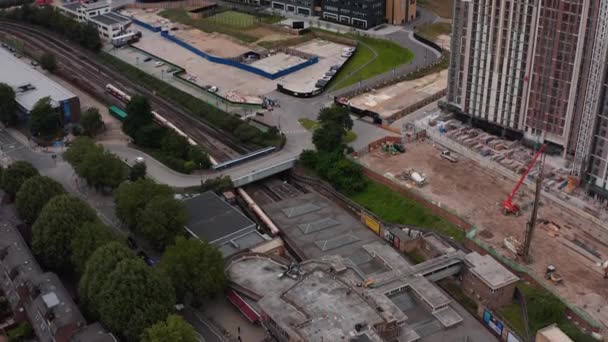 Landningsbilder på tåg som anländer till tågstationen i White City. Byggande av nya byggnader i bakgrunden. London, Förenade kungariket — Stockvideo