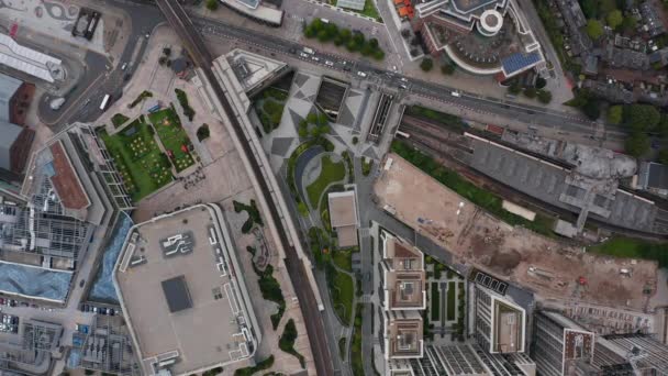 Aves aéreas vista desde arriba hacia abajo vista de la ciudad moderna borough con infraestructura de transporte. Edificios residenciales altos junto a la estación de tren. Londres, Reino Unido — Vídeos de Stock