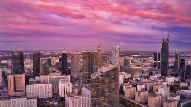 Zboară înainte deasupra zgârie-nori din centru în timpul apusului de soare. Imagini hiperlapse din centrul oraşului. Diminuarea cerului roz schimbarea culorii în albastru. Varșovia, Polonia — Videoclip de stoc