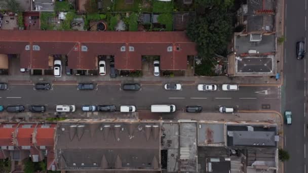 Воздушные птицы смотрят сверху вниз, нисходящий вид на улицу в жилом районе с машинами, припаркованными вдоль дороги. Лондон, Великобритания — стоковое видео