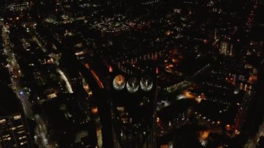 Strata yüksek binasının tepesinde üç rüzgar türbini var. Sürdürülebilir enerji kaynağı. Şehrin havadan gece görüşü. Londra, İngiltere