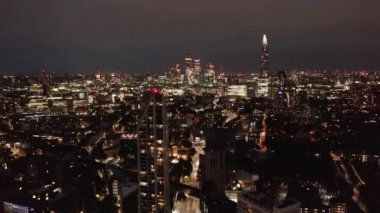 Gece ufuk çizgisinin aşağı ve yukarı görüntüsü. Şehir merkezindeki bir grup gökdelenle panoramik manzara. Londra, İngiltere