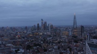 Şehir İş Merkezi 'ndeki yüksek ofis binalarının kaydırak ve pan görüntüleri. Gün batımında gökdelenlerle panoramik şehir manzarası. Londra, İngiltere