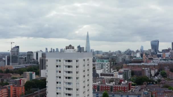 Vuela sobre altos edificios de apartamentos. Vista aérea de desarrollo residencial en la ciudad. Rascacielos modernos en la distancia. Londres, Reino Unido — Vídeo de stock