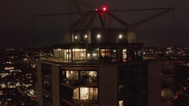 Орбита снималась на верхних этажах современного многоэтажного жилого дома Castilla. Окна светятся в темноте. Лондон, Великобритания — стоковое видео