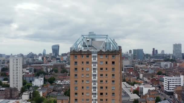 Survolez l'immeuble d'appartements de la tour, révélant les toits du centre-ville. Moderne design futuriste gratte-ciel dans le quartier des affaires. Londres, Royaume-Uni — Video