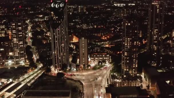 Deslize e filmagem pan de carros que atravessam a intersecção rodoviária na cidade. Vista aérea da rua iluminada à noite. Londres, Reino Unido — Vídeo de Stock