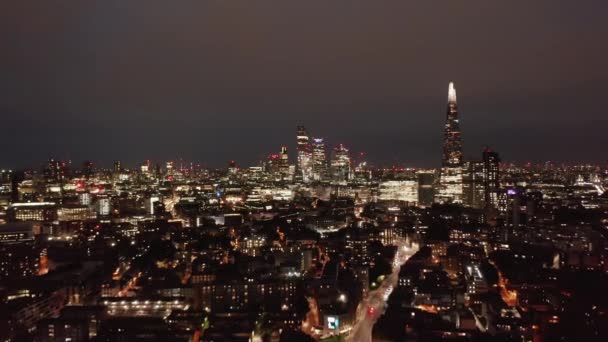 Pozpátku odhalují vrchol luxusního činžovního domu. Noční panorama města s vysokými kancelářskými budovami ve finančním centru města. Londýn, Velká Británie — Stock video