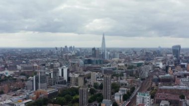 Şehrin üzerinden geriye doğru uç. Şehir merkezinin ve uzak gökdelenlerin havadan panoramik görüntüsü. Londra, İngiltere