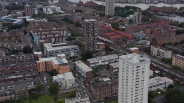 Kasaba gelişiminin kayan ve çekilen görüntüsü. Şehirdeki demiryolu hattındaki trenlerin hava görüntüsü. Arka planda modern iş bölgesinde gökdelenler var. Londra, İngiltere