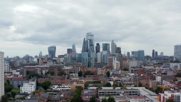 Панорамний вид на групу високих сучасних офісних будівель у фінансовому центрі міста. Попереду відкривається житловий будинок. Лондон, Велика Британія — стокове відео