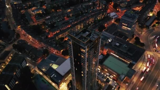 Aflopend perspectief uitzicht op de top van One The Elephant wolkenkrabber boven het verkeer in de straten van de nacht stad. Londen, Verenigd Koninkrijk — Stockvideo