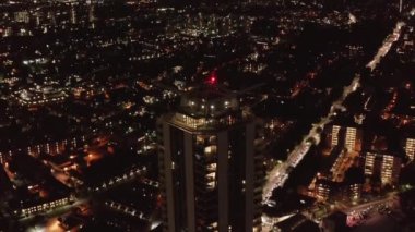 Gece şehir manzarasının hava görüntüsü. İleri doğru uçar ve yüksek binaların tepesine doğru eğilir. Sokakta trafik vardı. Londra, İngiltere