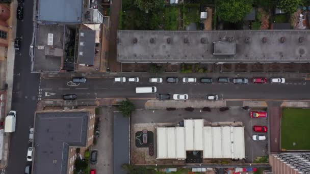 空中の鳥の目都市地区の狭い通りに移動する大きなバンの追跡の上にオーバーヘッド。道路沿いの駐車場。イギリスのロンドン — ストック動画
