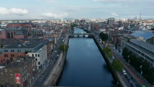 El río Liffey fluye tranquilamente por el centro de la ciudad. Hora punta y atasco de tráfico en las calles. Dublín, Irlanda — Vídeo de stock