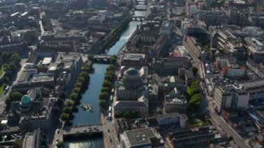 Nehir kenarlarında kubbeleri olan tarihi binaların havadan görünüşü. Liffey nehri üzerindeki köprülerde trafik vardı. Dublin, İrlanda