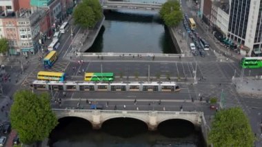 Şehirde toplu taşıma. Otobüsler ve tramvaylar Liffey nehri boyunca köprüden geçiyor. Şehir manzarasını yukarı kaldır. Dublin, İrlanda