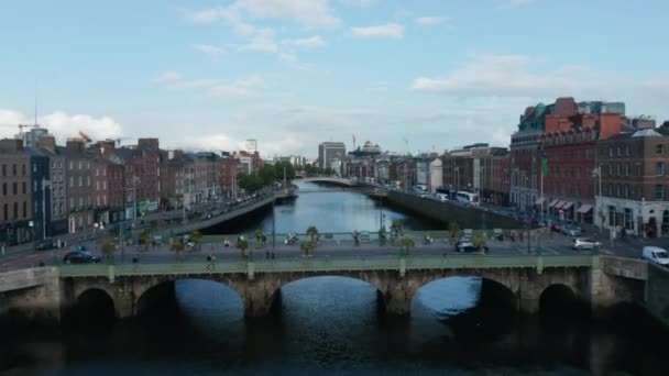 Adelante vuelan por encima del puente Liffey. Tráfico en puentes y frentes costeros. Edificios a lo largo del río. Dublín, Irlanda — Vídeo de stock