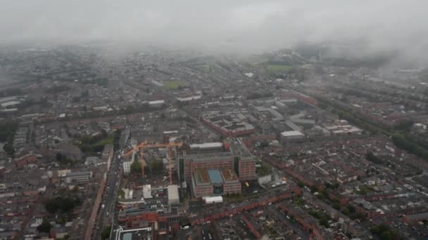 Ciudad en la niebla desde lo alto. Vista panorámica aérea del barrio de la ciudad. Grúas torre en obra. Dublín, Irlanda — Vídeo de stock