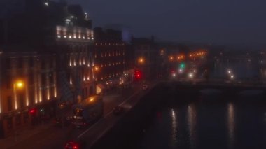 İleriye doğru aydınlatılmış rıhtım boyunca uçar. Şehir merkezinde sisli bir hava var. Karamsar atmosfer. Dublin, İrlanda