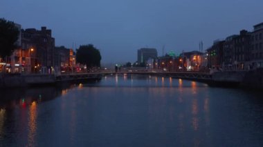 Akşam kentinde yaya geçidi üzerinde yürüyen yayalar. Gün batımından sonra şehrin yükselen görüntüleri. Dublin, İrlanda