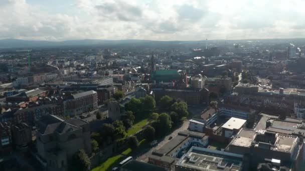 Fly above city, view against bright clouds and sunshine. Town development and public parks. Dublin, Ireland — Stock Video