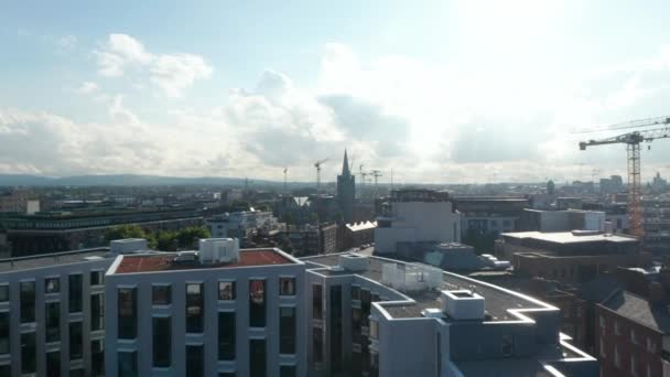 Sorvola il moderno complesso residenziale, dirigendosi verso la torre della Cattedrale di San Patrizio. Dublino, Irlanda — Video Stock