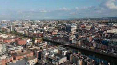 Şehir manzarasının panorama eğrisi görüntüleri. Liffey nehri boyunca caddeler ve binalar. Güneşli bir gün. Dublin, İrlanda