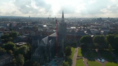 Aziz Patrick Katedrali 'nin yörüngesinde güneş ışığına karşı. Birçok vinç inşaata yardım ediyor. Dublin, İrlanda